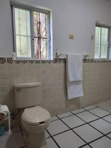 baño blanco con aseo y ventana en Departamento andree, en Puerto Vallarta