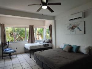 1 dormitorio con 1 cama, ventilador y ventana en Departamento andree, en Puerto Vallarta