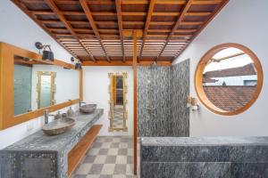 un bagno con due lavandini e uno specchio di The Secret Jungle Villas Berawa a Canggu