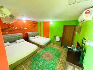 a room with two beds and a green and orange wall at DGeting Beach Resort in Tumpat