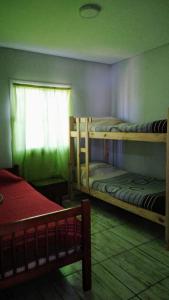 a room with two bunk beds and a window at Casa con piscina in Maipú