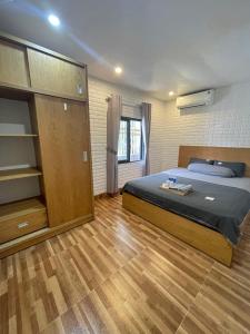 um quarto com uma cama e piso em madeira em THANH XUÂN HOMESTAY em Da Nang