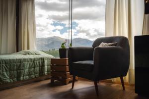 1 dormitorio con silla y ventana con vistas en Villa Aventura Lodge, en Cajamarca