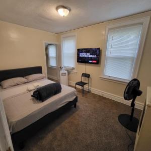 Schlafzimmer mit einem Bett und einem Flachbild-TV in der Unterkunft Z & Z Apartment in Newark
