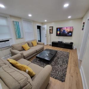 ein Wohnzimmer mit 2 Sofas und einem Flachbild-TV in der Unterkunft Z & Z Apartment in Newark