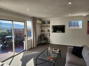 sala de estar con sofá y mesa de cristal en Roslyn Sanctuary Hereford St Dunedin, en Dunedin