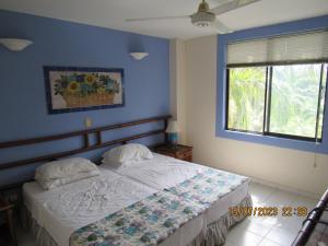 a bedroom with a bed with blue walls and a window at Condominio Girardot Resort INT 4 APTO 302 in Girardot