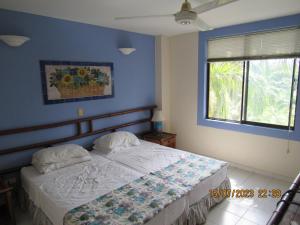 a bedroom with a bed with blue walls and a window at Apartamento Girardot Resort in Girardot +57 photos