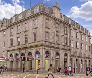 a large stone building with people walking in front of it at Aberdeen stay central 2-bedrooms apartment in Aberdeen
