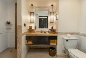 ein Badezimmer mit Waschbecken, Toilette und Spiegel in der Unterkunft Centara Kata Resort Phuket in Kata Beach