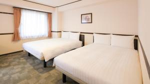 Postel nebo postele na pokoji v ubytování Toyoko Inn Yashio Ekimae