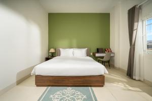 1 dormitorio con cama blanca y escritorio en Tashi Home en Da Nang