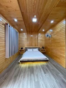 ein Schlafzimmer mit einem Bett in einer Holzdecke in der Unterkunft AN Homestay&coffee in Di Linh