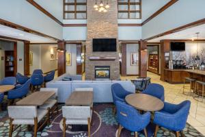 a lobby with tables and chairs and a fireplace at Staybridge Suites Wilmington East, an IHG Hotel in Wilmington