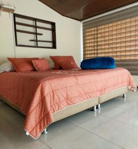 a bedroom with a large bed with red and blue pillows at Casa Estación Modelia, near to the airport. in Bogotá