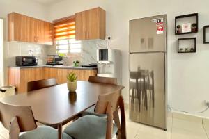 een keuken met een houten tafel en een koelkast bij 2BR Alanis Suite With Balcony in Sepang