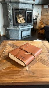 a leather book sitting on a wooden table in front of a fireplace at Kantokelo in Ylläsjärvi