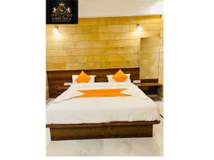 łóżko z pomarańczowymi i białymi poduszkami w pokoju w obiekcie Hotel Garh Vila w mieście Jaisalmer