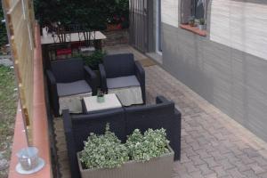 une terrasse avec 2 chaises, une table et des plantes dans l'établissement Gite la tuilerie, à Thuir