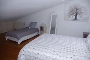 een slaapkamer met een wit bed en een boomafbeelding bij Gite la tuilerie in Thuir
