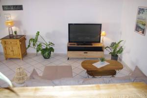 - un salon avec un canapé et une télévision dans l'établissement Gite la tuilerie, à Thuir