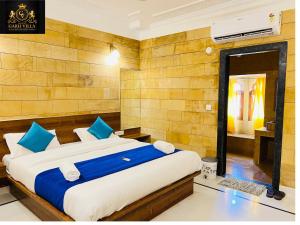 ein Schlafzimmer mit einem großen Bett mit blauen und weißen Kissen in der Unterkunft Hotel Garh Vila in Jaisalmer