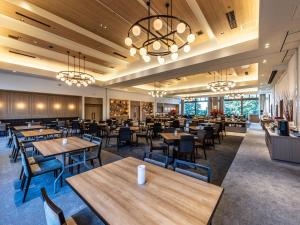 una sala da pranzo con tavoli e sedie in legno di APA Hotel & Resort Joetsu Myoko a Myoko