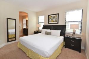 - une chambre avec un grand lit blanc et 2 fenêtres dans l'établissement Fountains Retreat condo, à Kissimmee