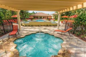 une terrasse avec une piscine et un bain à remous dans l'établissement Fountains Retreat condo, à Kissimmee