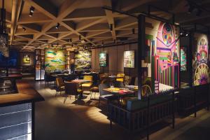 a restaurant with tables and chairs and colorful art on the walls at Hotel Indigo Tokyo Shibuya in Tokyo