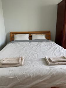 a white bed with two towels on top of it at Harry Hans Beach Apartment in Pärnu