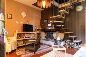 a living room with a fireplace and a staircase at Il Nido in Sestola