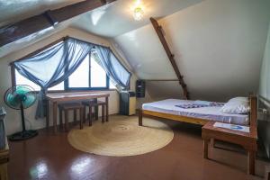 1 dormitorio con cama, mesa y ventana en Bangka Hostels en El Nido