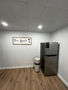 a room with a refrigerator and a sign on the wall at Cozy Home- Winnipeg Airport, Downtown and Polo Park in Winnipeg