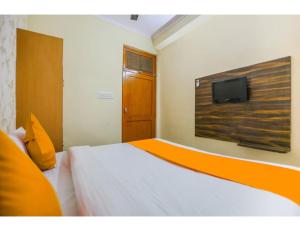 sypialnia z łóżkiem i telewizorem na ścianie w obiekcie Hotel Rukmani Palace, Sri Ganganagar w mieście Gangānagar