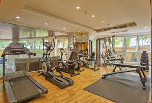 a gym with several treadmills and elliptical machines at Nova Gold Hotel Pattaya in Pattaya