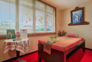 ein Schlafzimmer mit einem Bett und einem Tisch in einem Zimmer in der Unterkunft Nova Gold Hotel Pattaya in Pattaya
