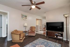 a living room with a flat screen tv and two chairs at Dual-Family Retreat Sunlit Haven in Columbus