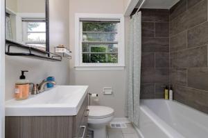 a bathroom with a sink and a toilet and a window at Dual-Family Retreat Sunlit Haven in Columbus +18 photos