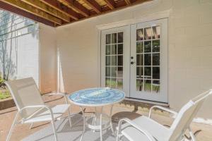patio ze stołem i krzesłami na ganku w obiekcie Dual-Family Retreat Sunlit Haven w mieście Columbus
