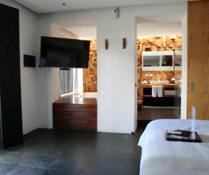 1 dormitorio con 1 cama y baño con bañera en Hotel Boutique MO17, en Querétaro