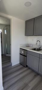 een keuken met een wastafel en een aanrecht bij Tiny house in the heart of MOVAL private freeparking Netflix in Moreno Valley