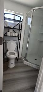 a bathroom with a toilet and a glass shower at Tiny house in the heart of MOVAL private freeparking Netflix in Moreno Valley