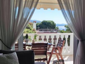 a patio with a table and chairs on a balcony at Varkiza Sea View Apartment - Free Parking in Vari