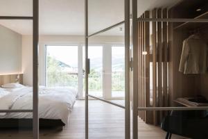 a bedroom with a bed and a sliding glass door at Astor Apartments in Valdaora