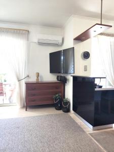 a living room with a flat screen tv on the wall at Varkiza Sea View Apartment - Free Parking in Vari +23 photos