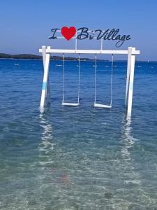 a bench in the water with a heart on it at Lux Camp Bi Village, Mobile home Villa Dado in Fažana