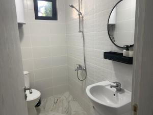 een witte badkamer met een wastafel en een spiegel bij Villa Sea House 2 in Byala