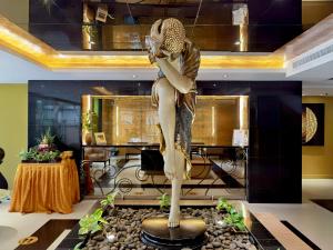 Una statua di una donna seduta su un tavolo di Nova Gold Hotel Pattaya a Centro di Pattaya