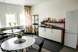 uma cozinha e sala de jantar com mesas e um frigorífico em Spångholmen B & B em Mjölby